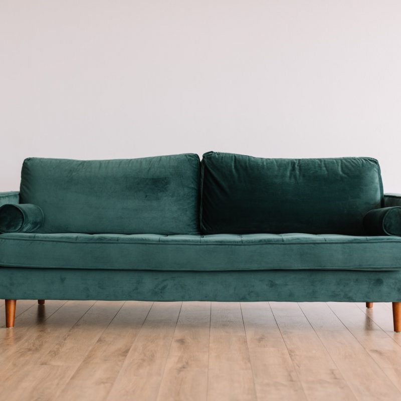 Green sofa with wooden legs